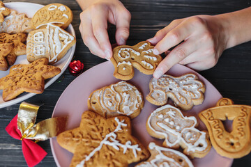 Boy is decorating gingerbread cookies with icing sugar. Snowflake, star shapes. Holiday, celebration and cooking concept. New Year and Christmas postcard, close up.	