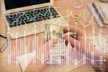 Multi exposure of financial graph drawing hologram and USA dollars bills and man hands. Analysis concept.