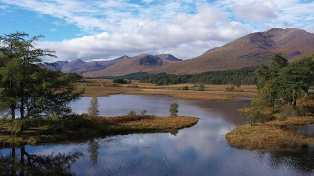 aerial drone image of loch tulla in the argyll region of the highlands of scotland during autumn on a clear bright day showing calm waters on the inland loch