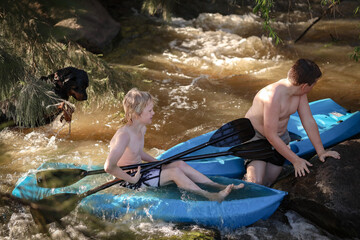 Two boys kayaking in rapids on Goulburn River in New South Wales near Mudgee. Holiday photos on Australian road trip.