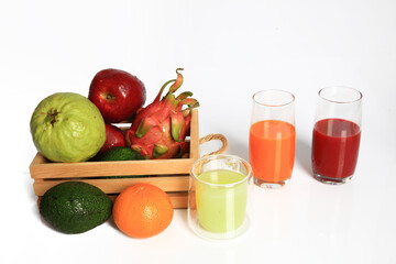 Variouse fresh fruit in wooden basket and juice in glasses