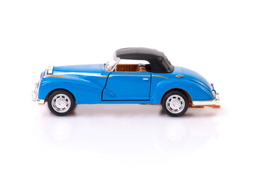 Side view of blue clasic design toy car with black roof.