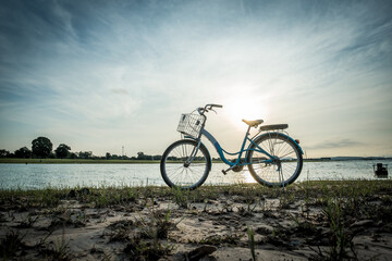 Obraz premium Silhouette vintage bicycle near the beach during sunrise.