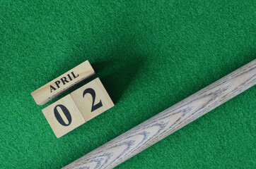 April 2, Number cube With a snooker stick on a green background, snooker table.