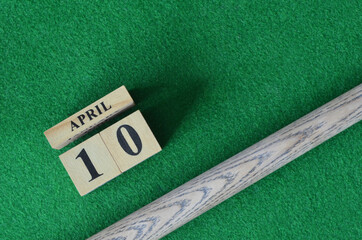April 10, Number cube With a snooker stick on a green background, snooker table.