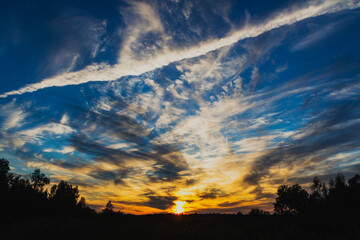 Colorful sunset with light and dark clouds.