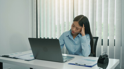 Young asian women are worried or stressed about working at the corporate office.