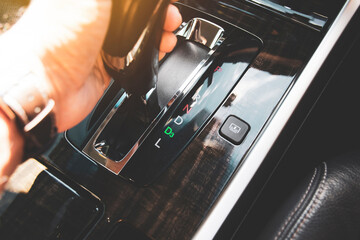 The driver's hand moved the gear selector to the drive three (D3) mode of the automatic transmission in the car