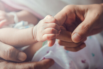Newborn baby holding mother's hand. - obrazy, fototapety, plakaty
