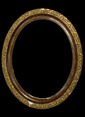 Old oval wooden picture frame isolated on black background.