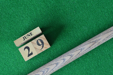 June 29, Number cube With a snooker stick on a green background, snooker table.