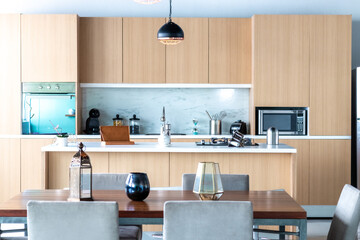 Contemporary white kitchen with island, in blue and beige tones. Interior design