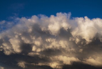 Naklejka na ściany i meble This image shows large rain clouds threatening a bright blue sky.