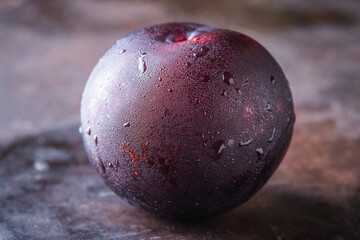 Freshly harvested red plum with condensation at cold autumn morning. Selective focus. Shallow depth of field.