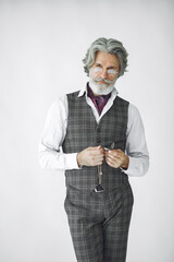 Close up portrait of grinning old-fashioned man. Elegant man in a studio. Grandfather with a clock.
