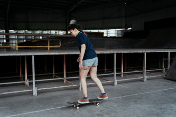 Obraz premium Skate board player woman on stand on a board.
