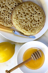Breakfast of crumpets and honey with lemon.