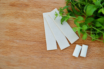 Bunch of fresh mint, lozenges and gum pads on wooden background
