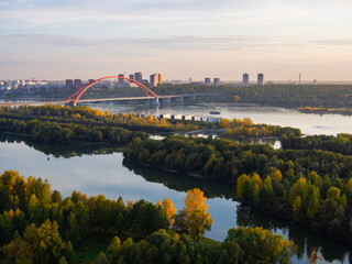 Bugrinsky bridge over the Ob River in Novosibirsk at sunset. A bridge with an orange arch over a river.