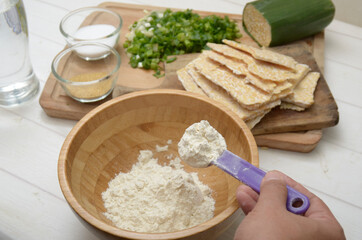 puting several spoon of flour, to make a dough. preparing making tempe mendoan, indonesia culinary