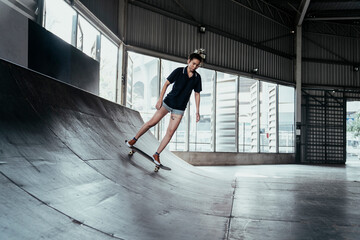 Obraz na płótnie Canvas Skateboard player woman rinding board on rusty curve.