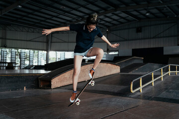 Skateboard player woman doing jump flip.