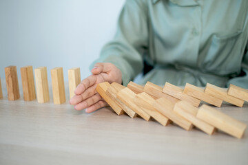 Businesswoman hand stop wooden blocks for protect other wooden block, Concept Risk of management and strategy plan