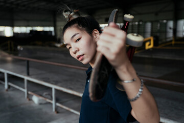 Close up - Skate board player woman with board over head.