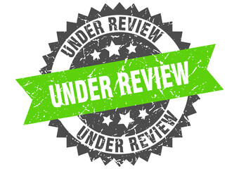 under review stamp. grunge round sign with ribbon