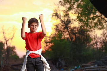 Happy and excited child doing winner gesture with arms raised