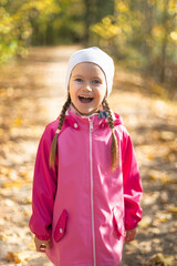 Moscow /Russia -10 04  2020: Happy little girl resting and walking in nature in the autumn forest  near the lake in Moscow region of Russia with yellow and orange autumn leaves