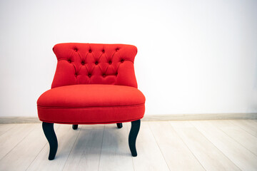 Antique red armchair in white room