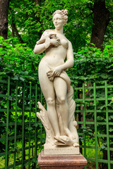 Fototapeta na wymiar Marble statue Allegory of Salacity in old city park Summer Garden in St. Petersburg, Russia