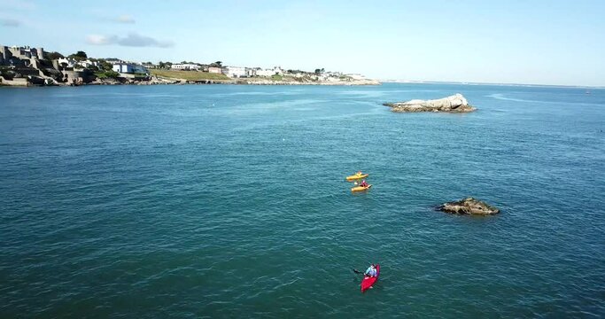 Aerial of 3 kayaks  paddling out to Dalkey Island watched be a seal.