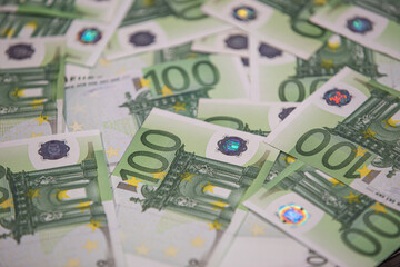 Obraz na płótnie Canvas Background text of one hundred euro bills. Selective focus.
