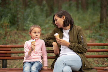 Fototapeta na wymiar Cute toddler girl and mother eating ice-cream