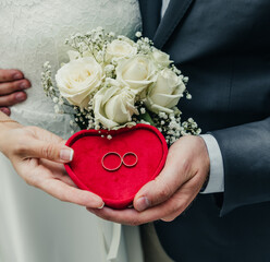 white gold wedding rings in a box and a bridal bouquet of delicate roses and greenery