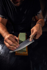 Hands sharpening Japanese chef knife