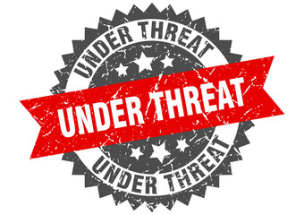 under threat stamp. grunge round sign with ribbon