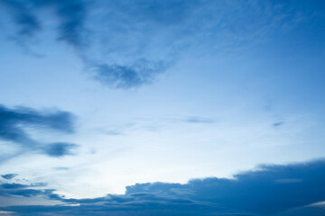 Naklejka na ściany i meble Dramatic clouds in the blue sky at sunset.