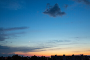 sunset sky with moon over the city