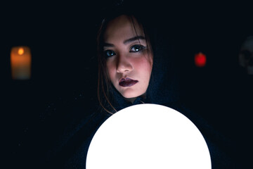 Portrait of Asian fortune teller in black hood.