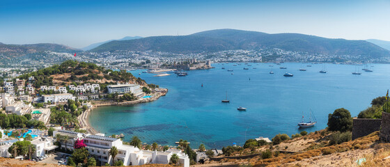 Panorama of Bodrum coastline with harbor and ancient fortress. Seascape with sailboats and luxury yachts in harbor on the Aegean sea in Bodrum, Turkey.