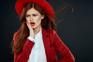 Pretty woman with red lips hat on her head jacket elegant style charm dark isolated background