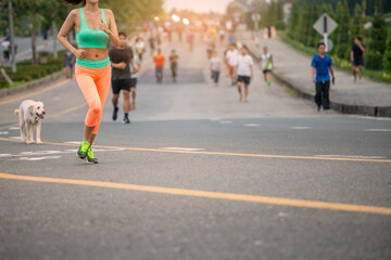 Obraz premium Healthy woman with group of people exercising running , walking on morning park road.