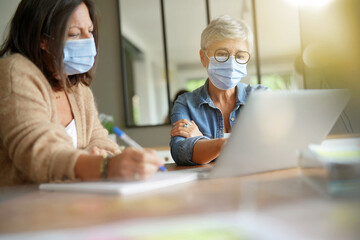 Business women working in office with face mask