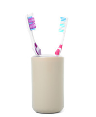 Cup with tooth brushes on white background