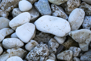 stone pebble beach near river. natural background of cobblestones, pebbles and stones of different shapes, colors and textures.