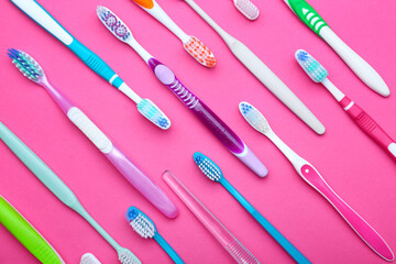 Many tooth brushes on color background