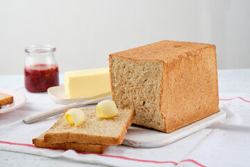 Butter curl on toast bread. Healthy breakfast with bran bread toast, butter and jam.